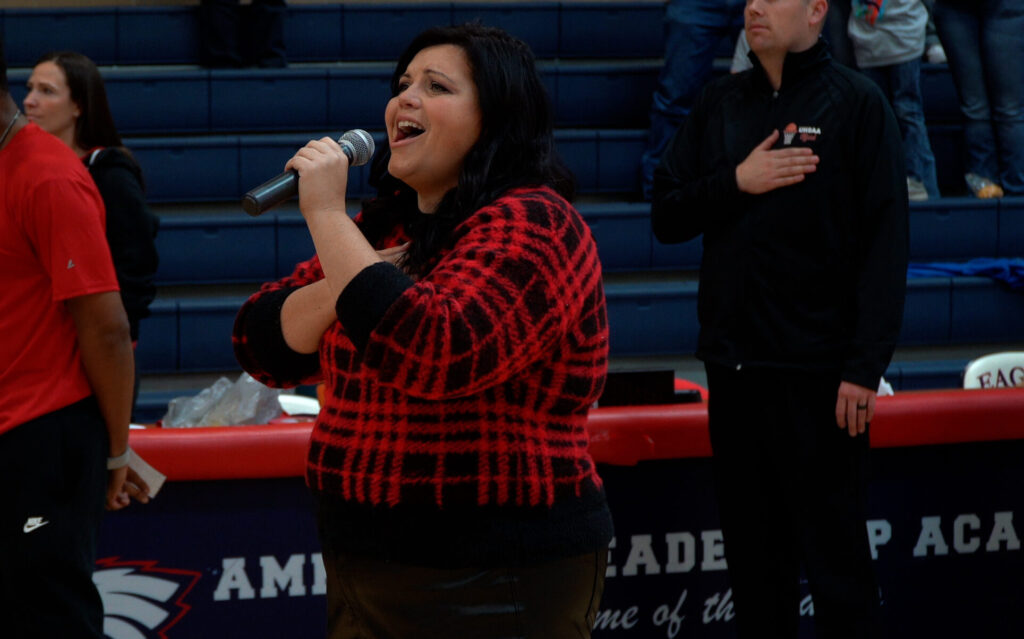 Mrs. Christensen Singing the National anthem at a ALA Basketball game